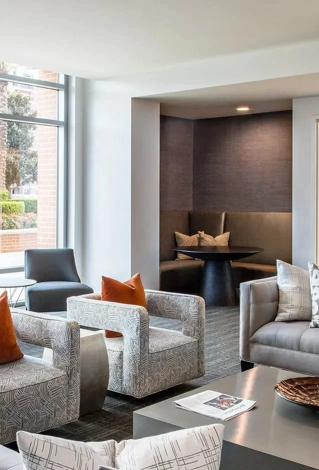 Luxury commercial interior design lounge in Houston with tailored seating, built-in banquette, and modern neutral finishes