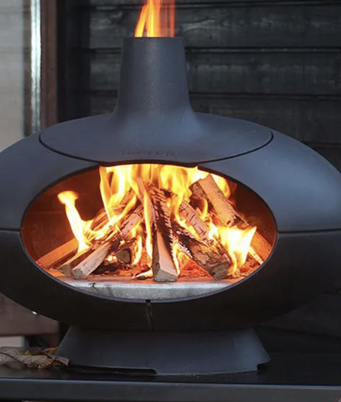 Modern outdoor fireplace with flames and wood burning inside