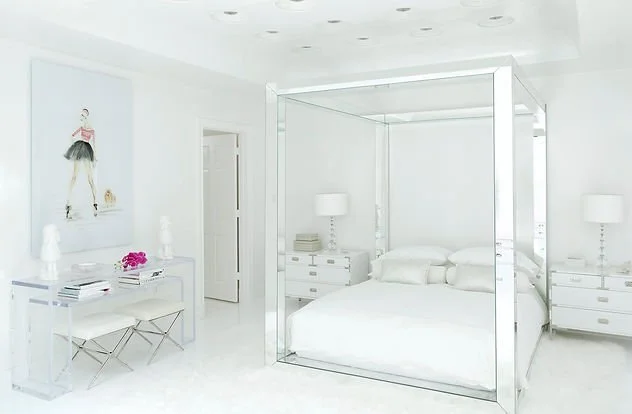 Minimalist white bedroom with a modern canopy bed, sleek furniture, and a ballerina artwork on the wall.