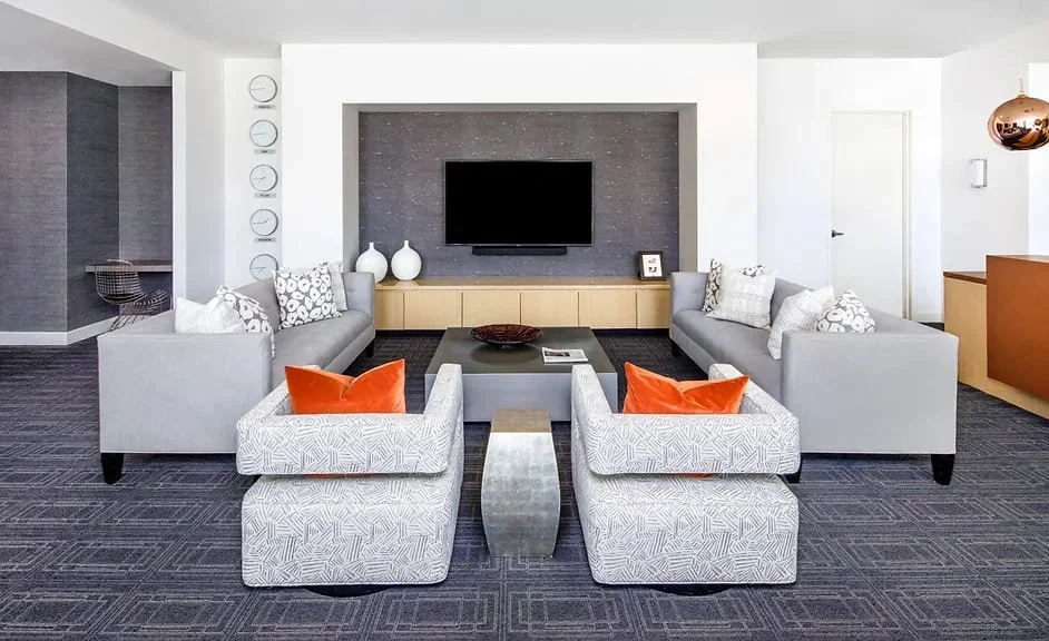 Contemporary residential living room design at Highland Tower Houston showcasing symmetrical seating layout, custom media wall, and elevated urban condominium styling.