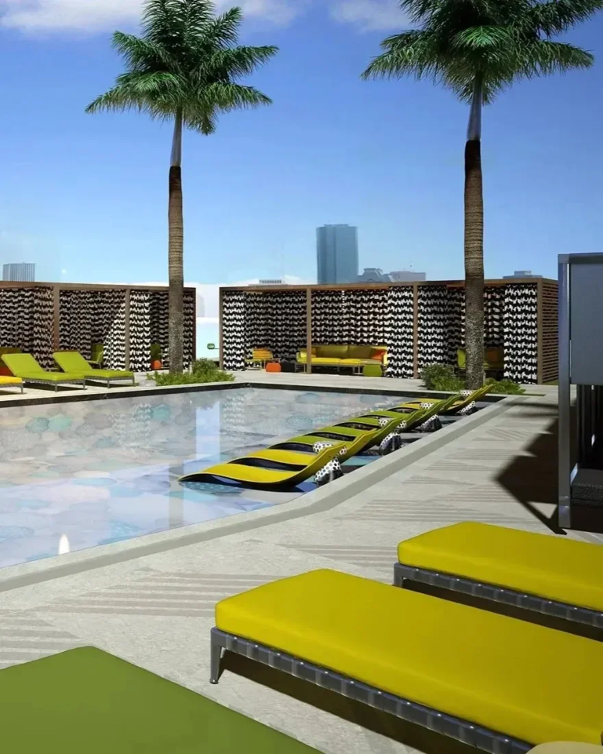 Rooftop pool area with yellow lounge chairs, palm trees, and a cityscape background.