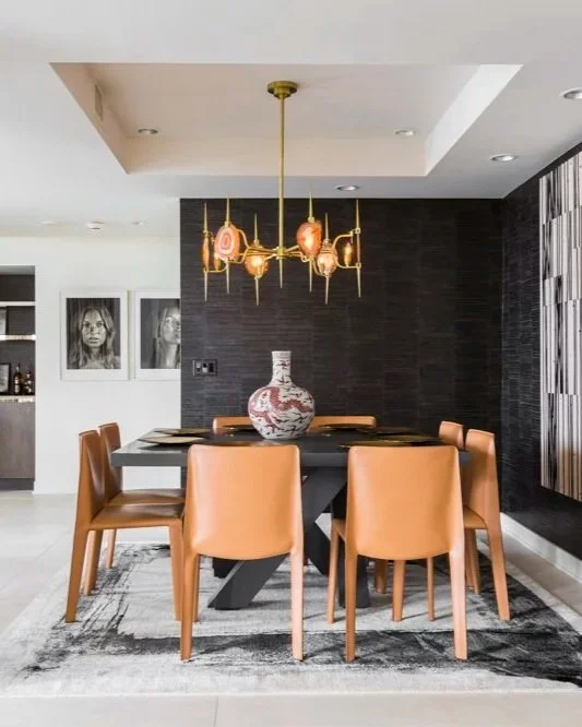 Contemporary luxury dining room in Houston with sculptural lighting, bold artwork, and tailored leather seating at Greenway.