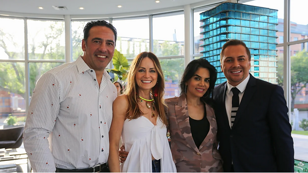 Group of four people smiling indoors with city view background
