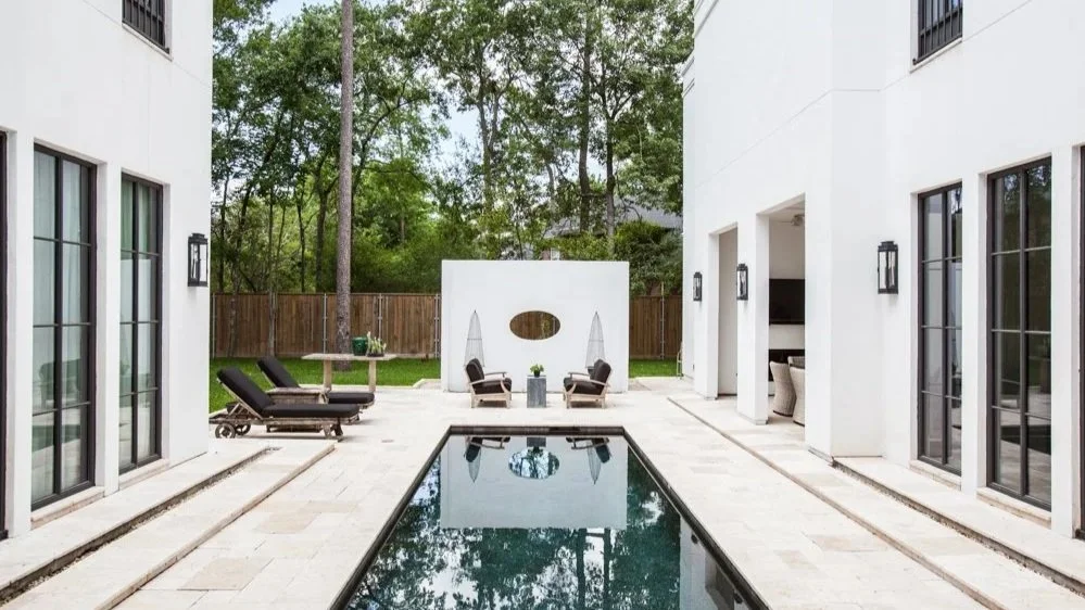 Luxury residential exterior design in Houston at the Bunker Hill residence featuring symmetrical architecture, private courtyard pool, and refined contemporary landscaping.