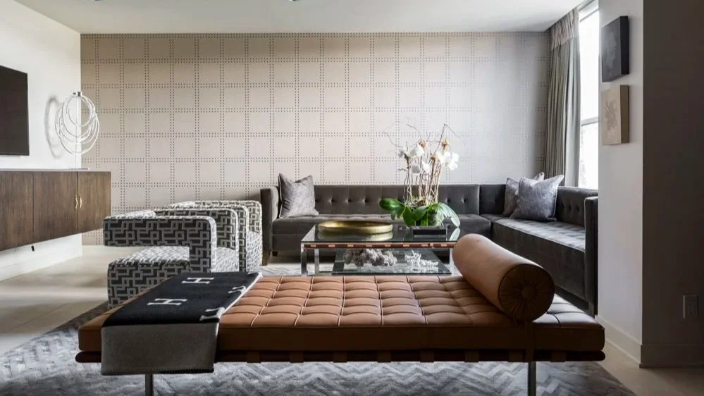 Modern high-end living space in Houston featuring architectural staircase, custom millwork, and curated art at Greenway residence.
