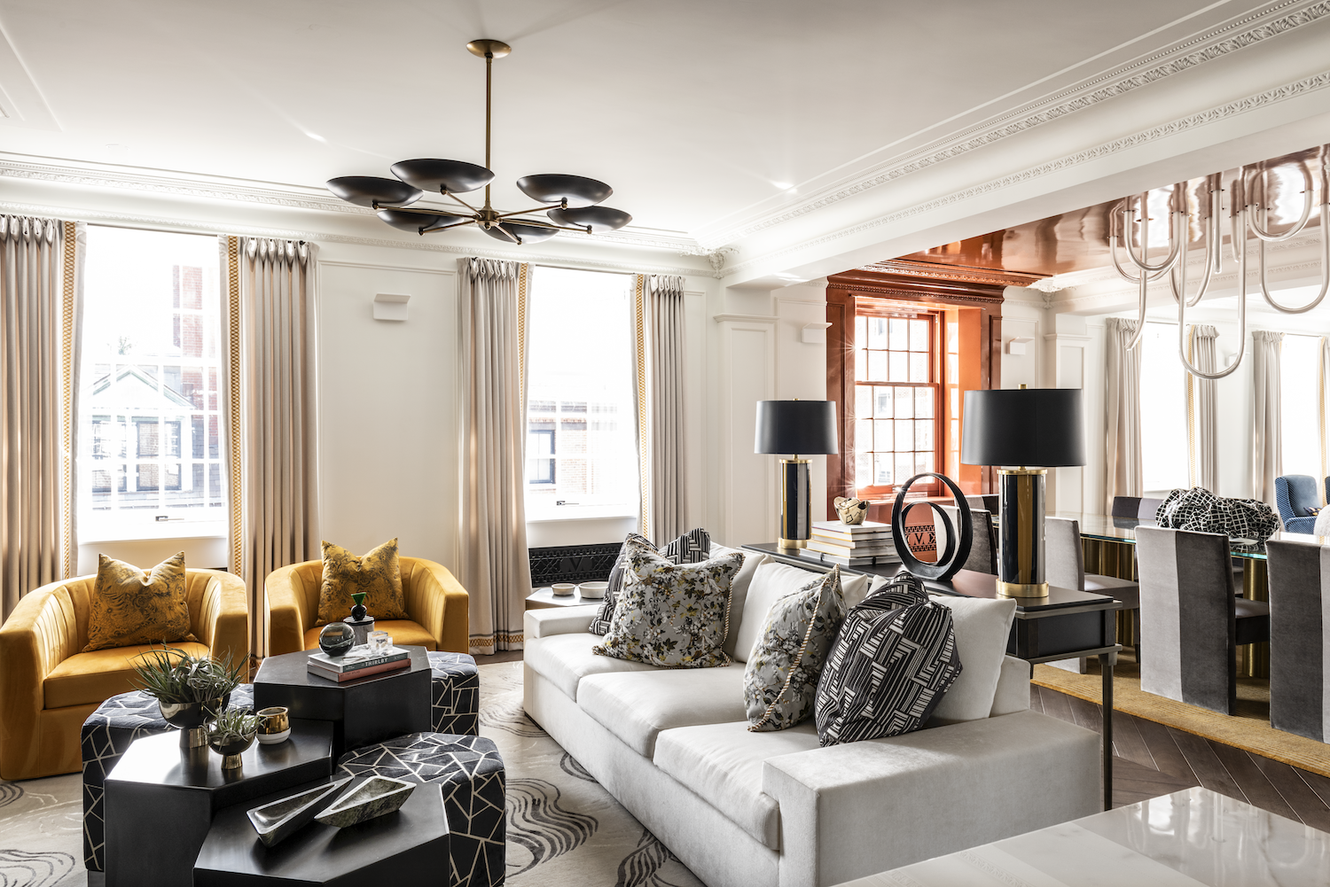 Luxury residential interior design formal living room with sculptural lighting, layered seating, and warm architectural detailing