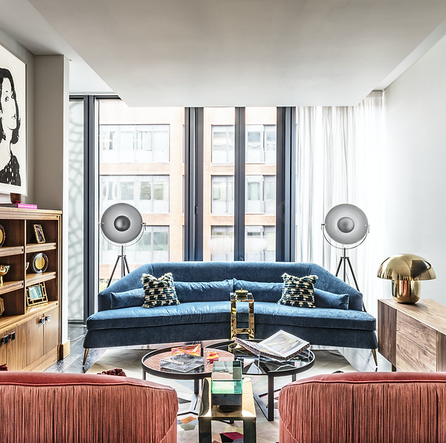 Modern living room with a blue sofa, floor lamps, and eclectic decor.
